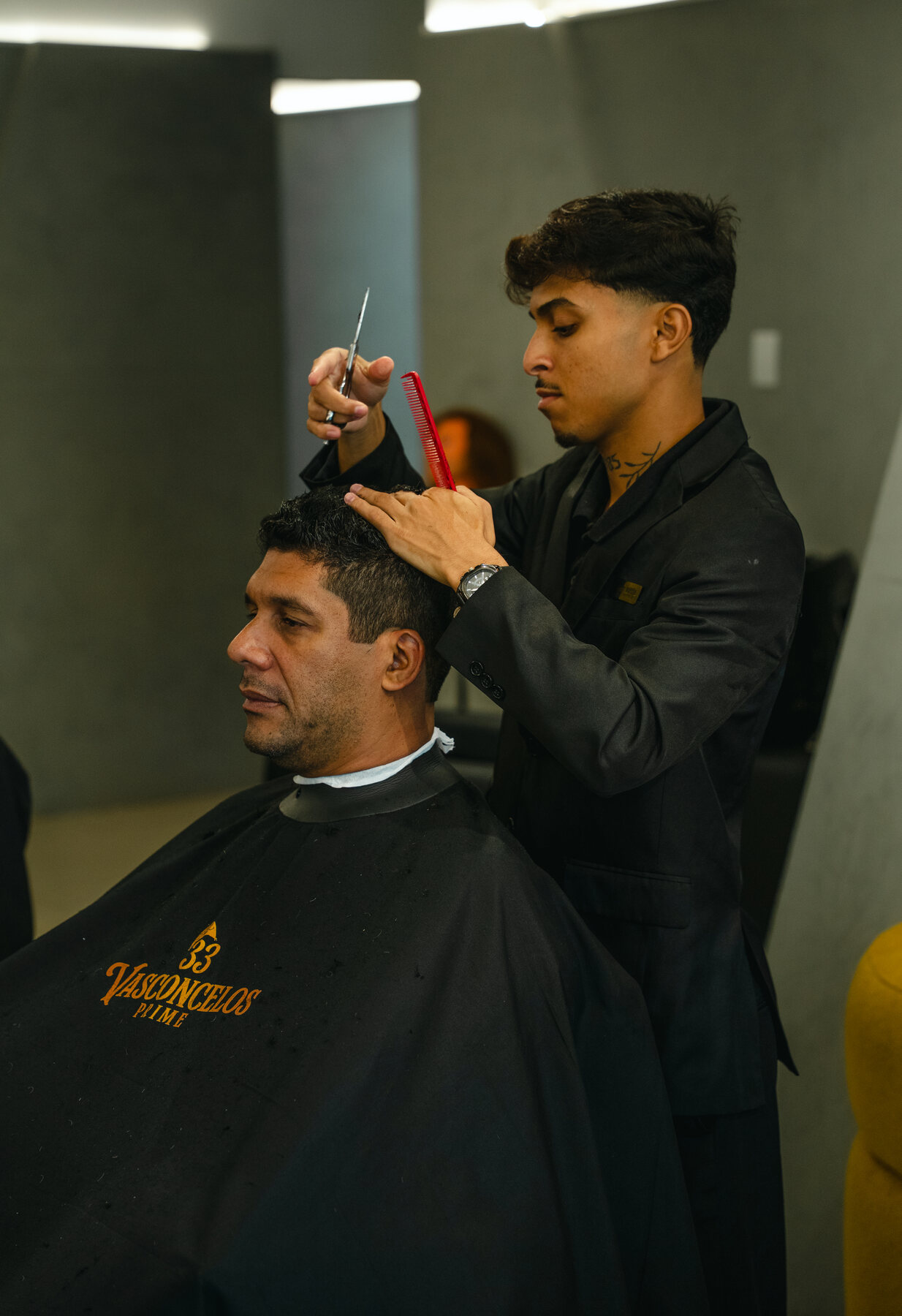 Barbeiro realizando corte masculino com tesoura