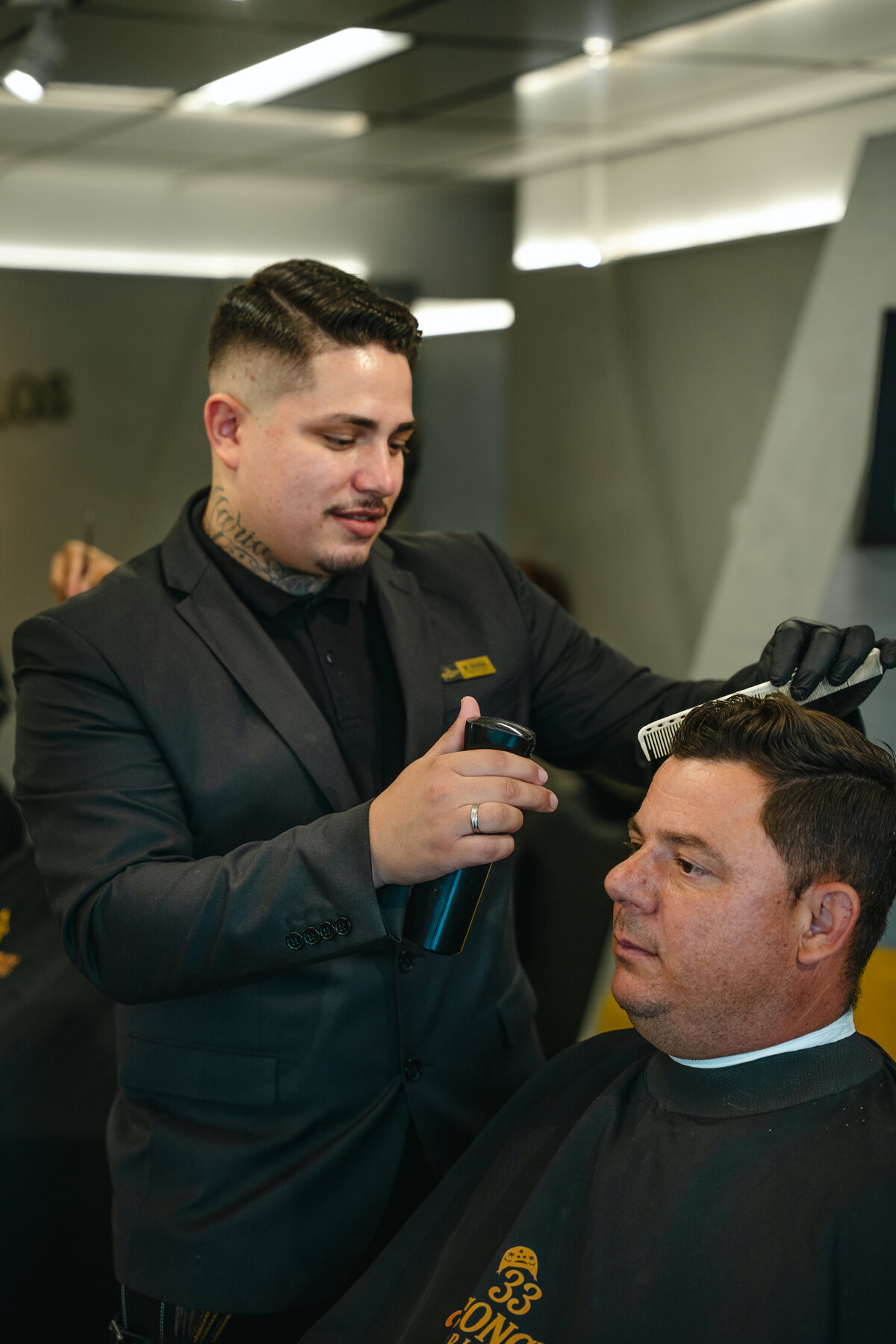 Barbeiro finalizando um corte masculino